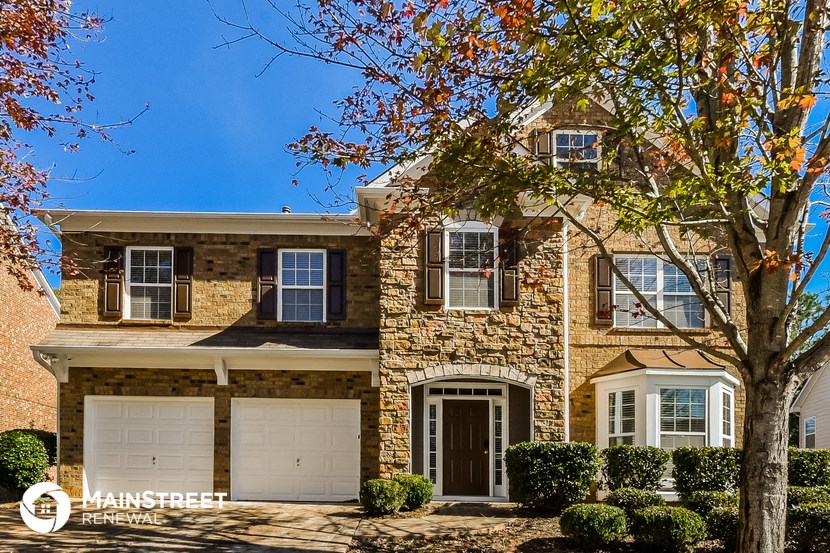 a house with two garage doors and a tree in front of it