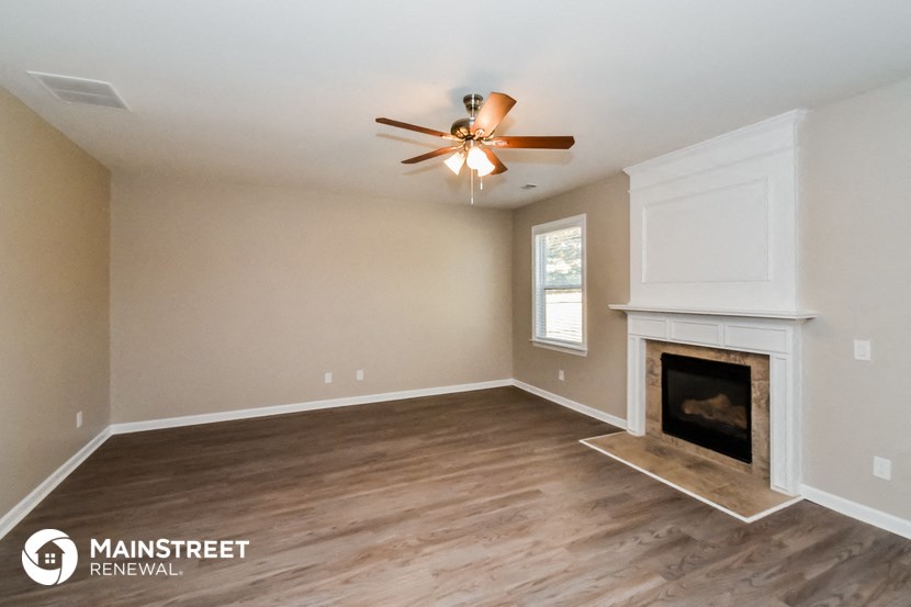 the living room with fireplace and ceiling fan