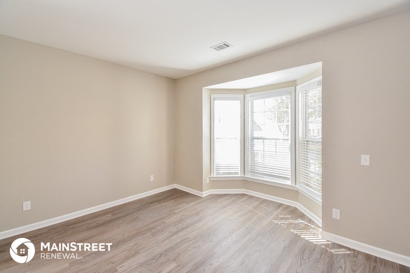 the living room of a new home with wood floors and a large window