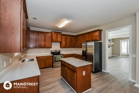 a kitchen with wooden cabinets and a stainless steel refrigerator