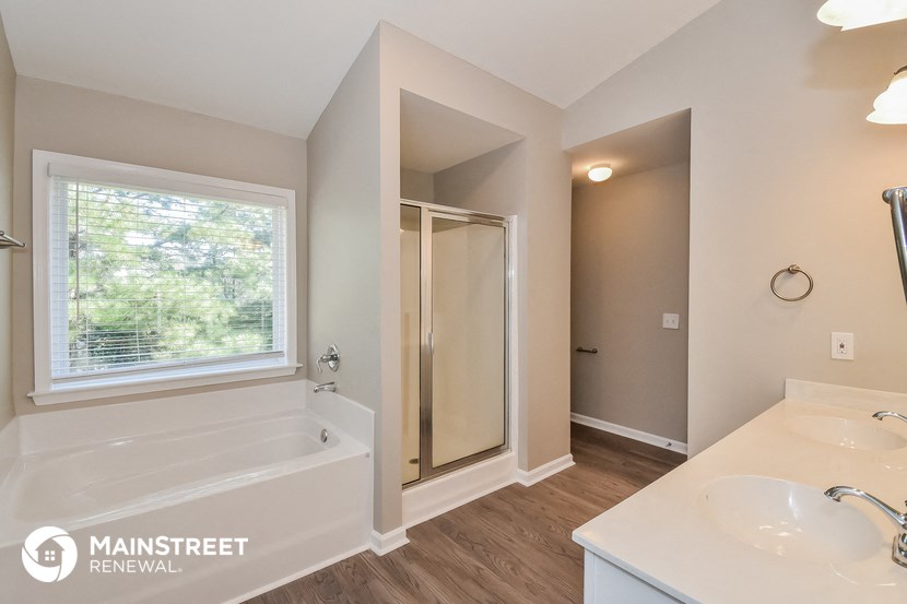 the master bathroom has a tub and a shower and a sink