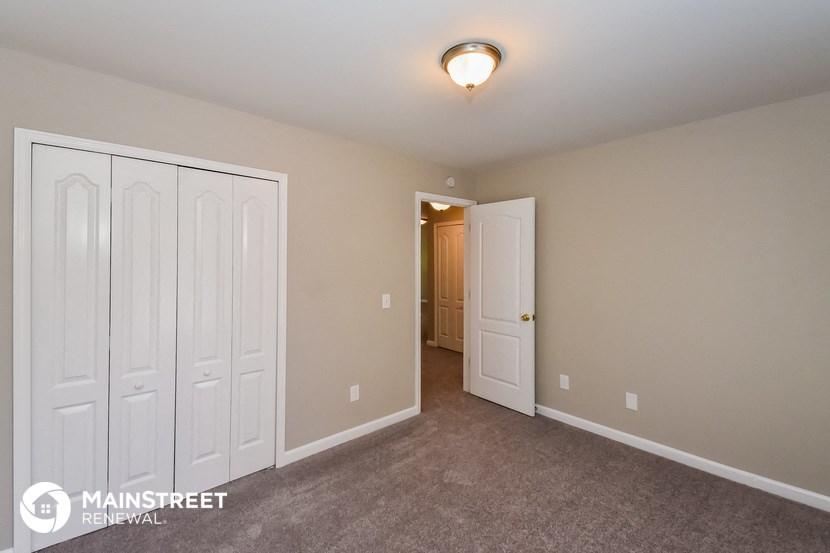 a bedroom with two closets and a door to a hallway
