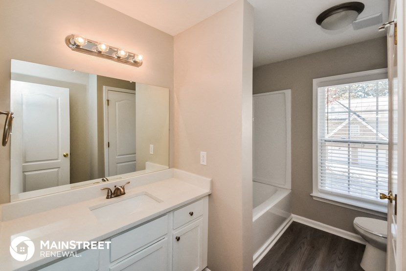 a bathroom with a large mirror and a sink and a toilet