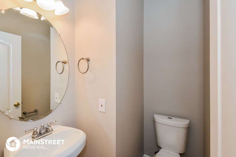 a bathroom with a toilet and a mirror and a sink