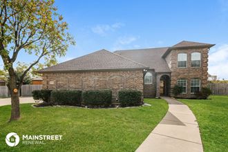 a large brick house with a sidewalk in front of it