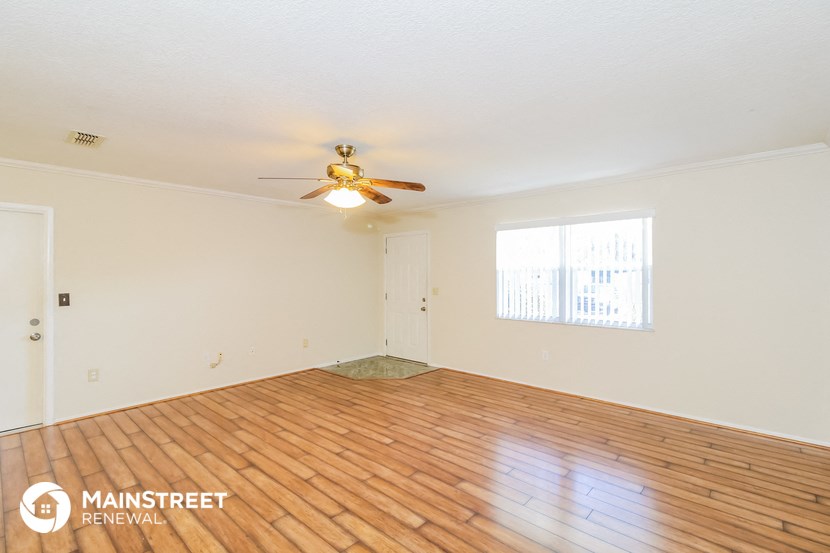 a living room with a wood floor and a ceiling fan