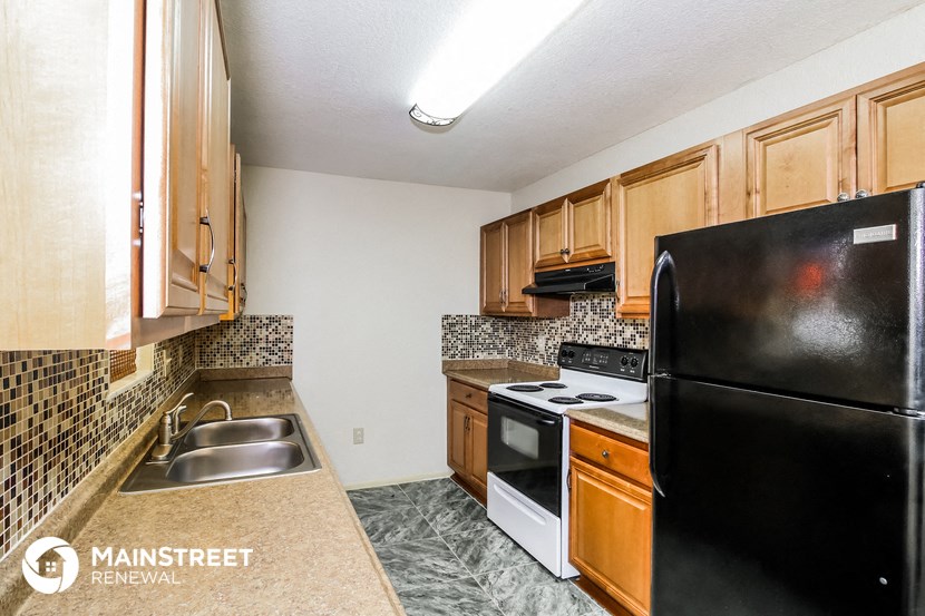 a kitchen with a stove refrigerator and sink