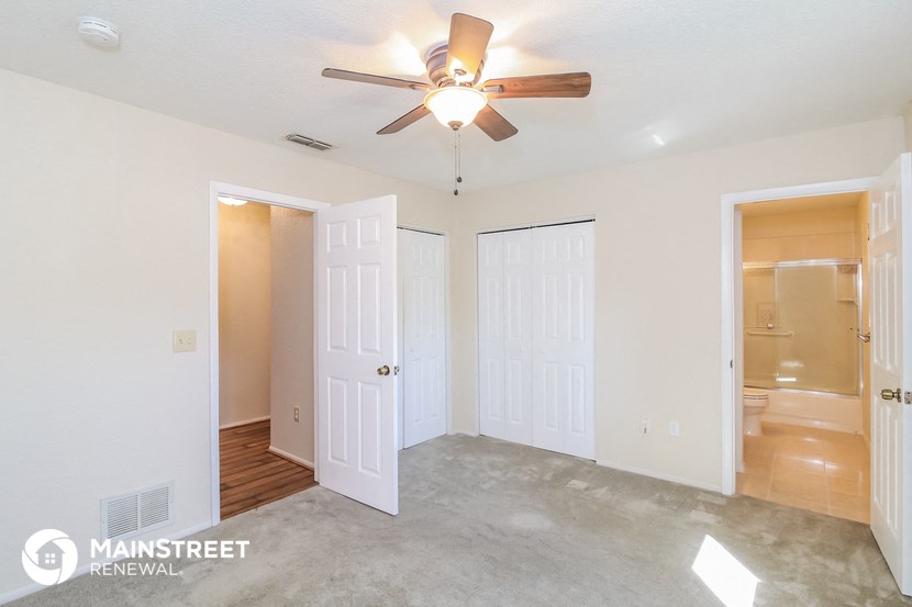 an empty bedroom with a ceiling fan and a closet