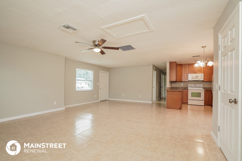 an empty kitchen and living room with a ceiling fan