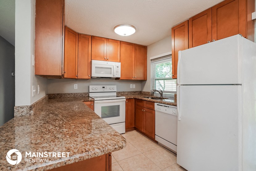 a kitchen with white appliances and granite counter tops