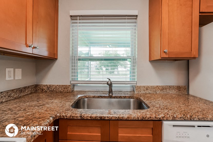 a kitchen counter with a sink and a window