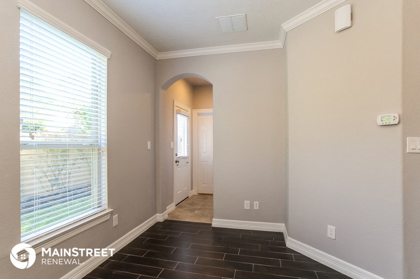 the entryway of a home with a large window and tiled floor