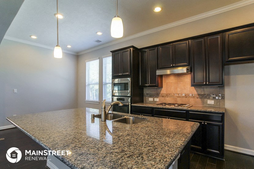 a kitchen with black cabinets and granite counter tops