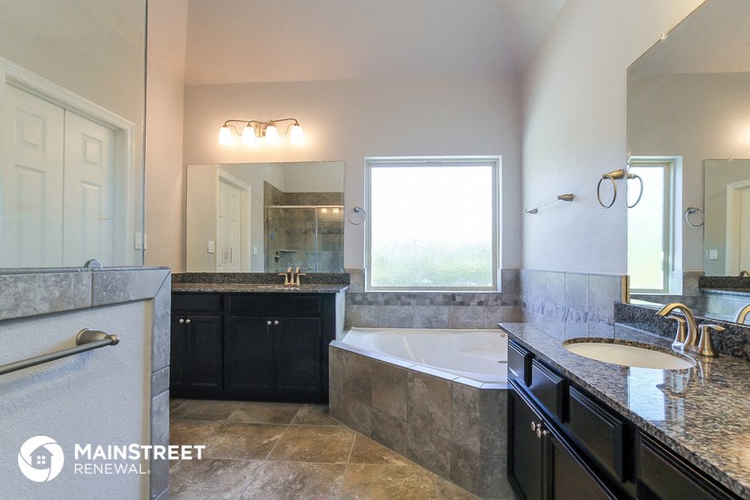 a bathroom with a tub and a sink and a mirror