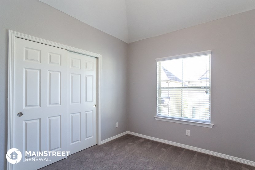 a bedroom with a white door and a window