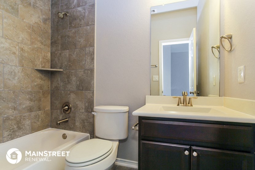 a bathroom with a toilet sink and shower and a mirror