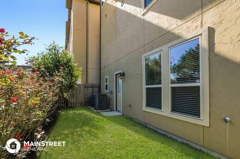 the yard of a house with a green lawn and a window