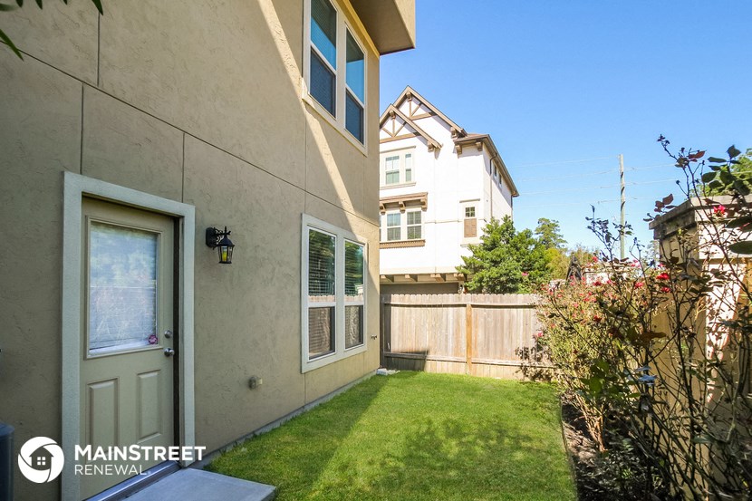 the backyard of a house with a lawn and a fence