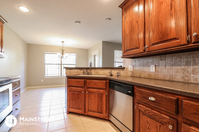 full view of the kitchen with wood cabinets and tiled floor