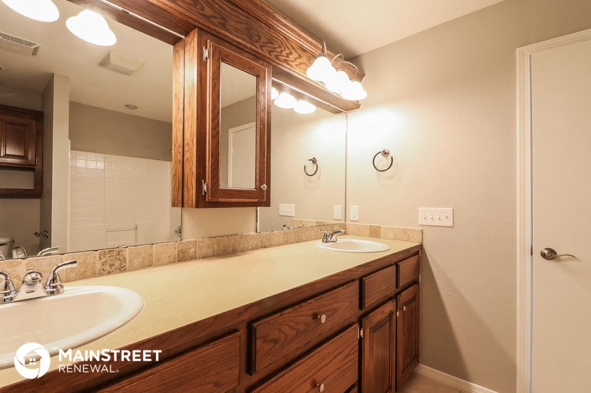 a bathroom with two sinks and a large mirror