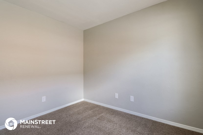 an empty room with carpet and white walls