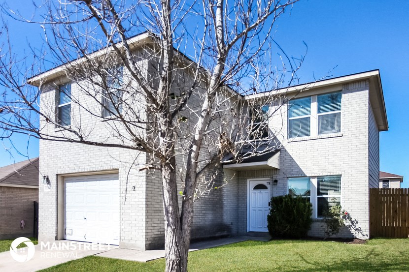 a white brick house with a tree in front of it
