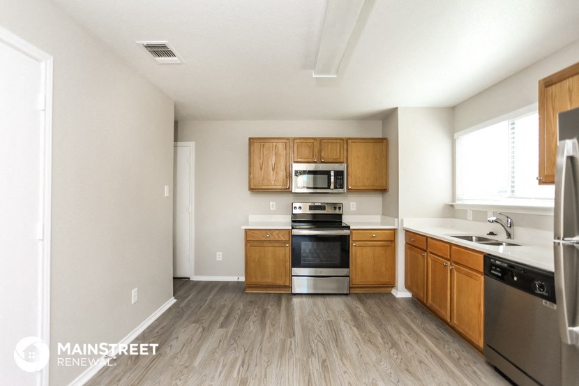 a kitchen with wooden floors and stainless steel appliances