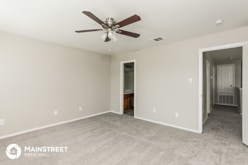 an empty living room with a ceiling fan