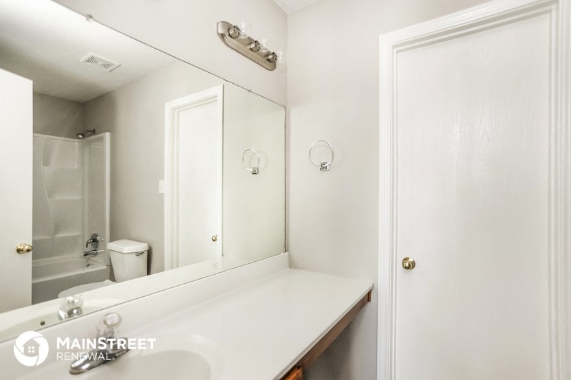 a white bathroom with a sink and a mirror