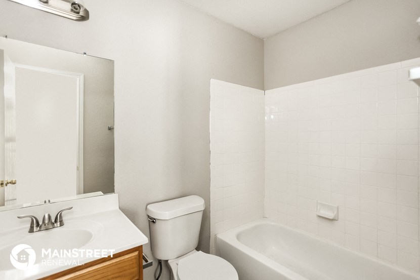 a white bathroom with a toilet and a tub and a sink