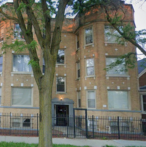 a large brick building with a tree in front of it