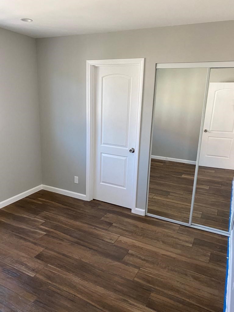 a room with a mirror and a wooden floor