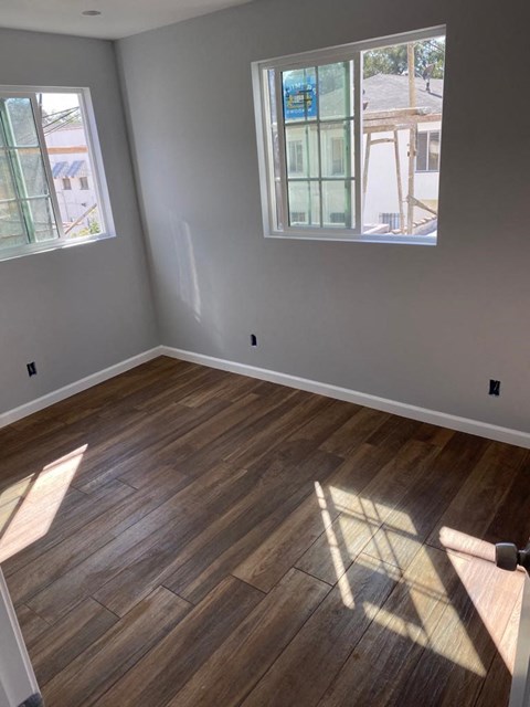an empty room with wooden floors and a window