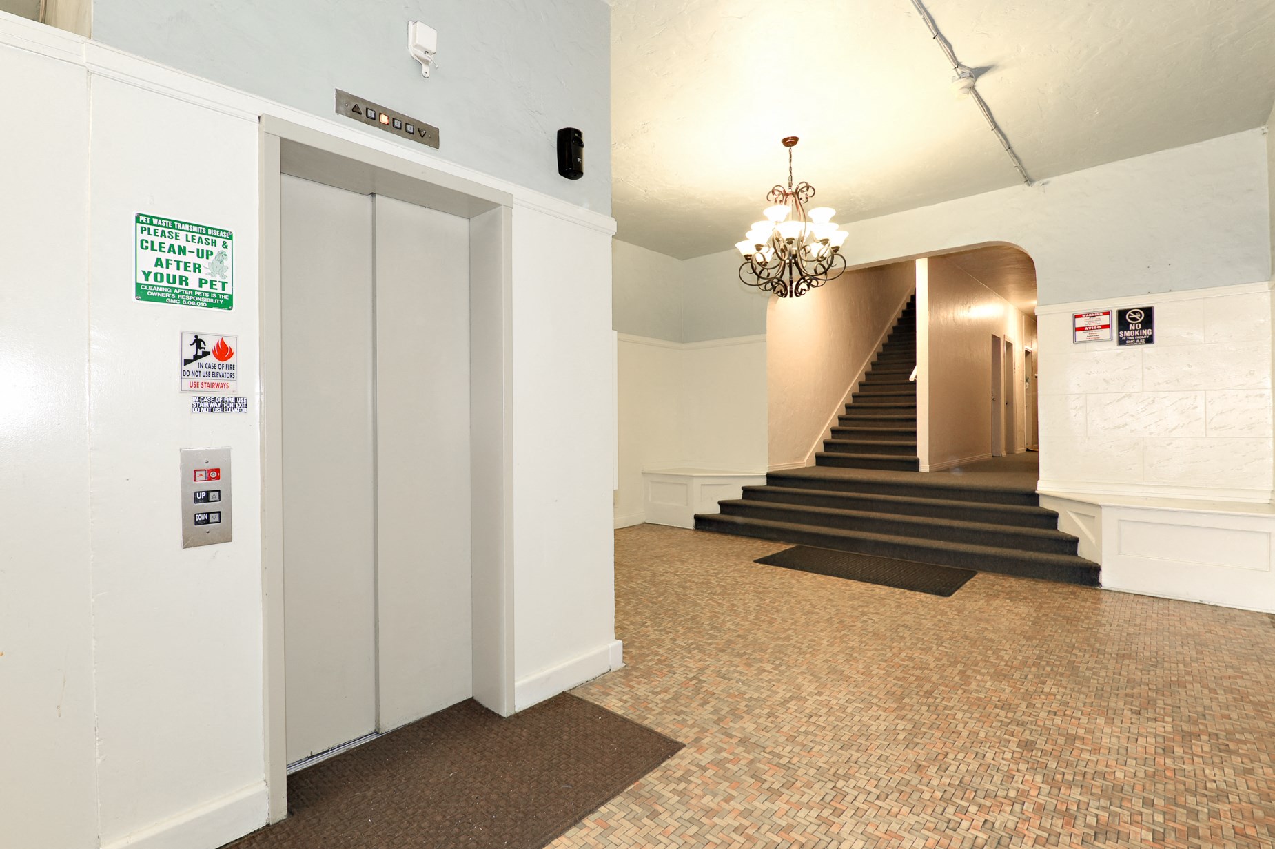 the lobby of a building with a staircase and a chandelier
