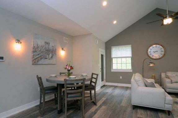 a living room and dining room with a clock on the wall
