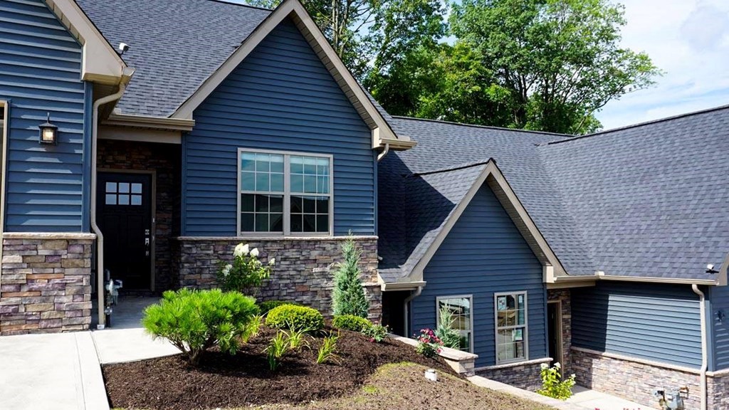 a blue house with a sidewalk in front of it
