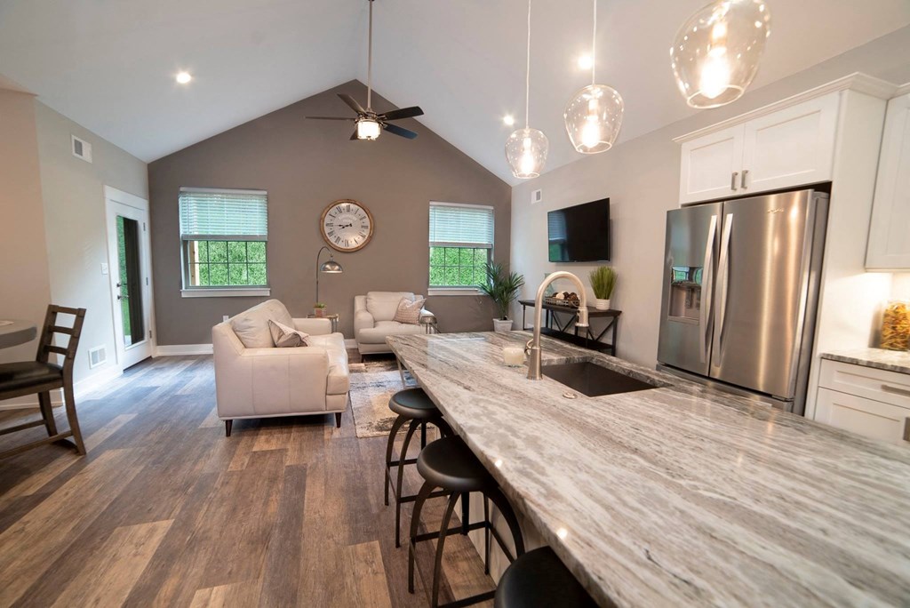 a kitchen with a long counter top and a stainless steel refrigerator
