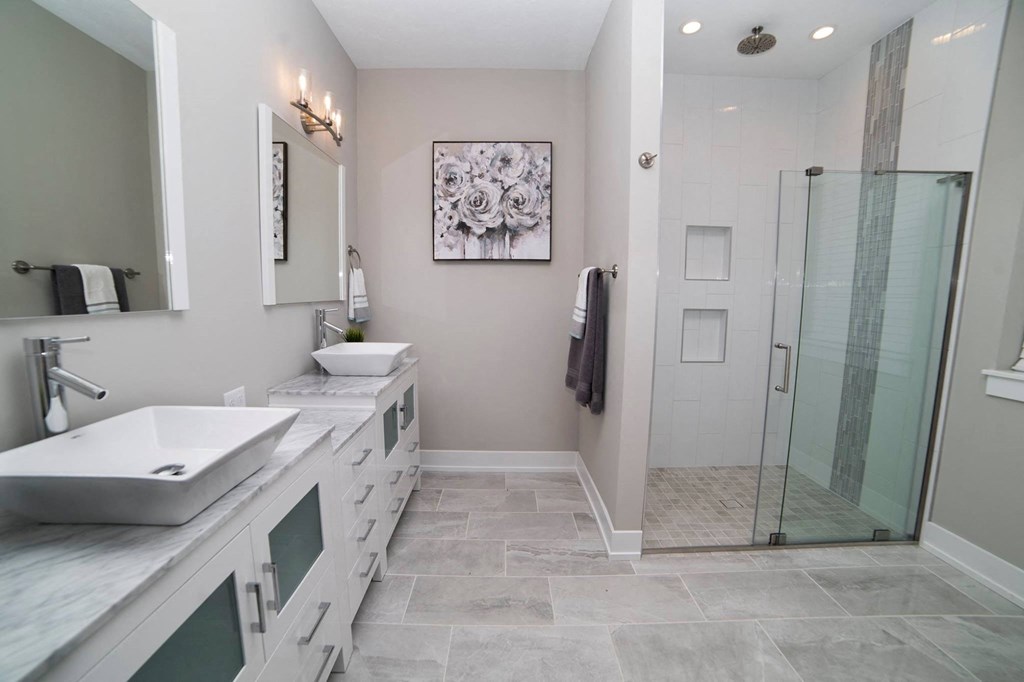 a white bathroom with two sinks and a shower