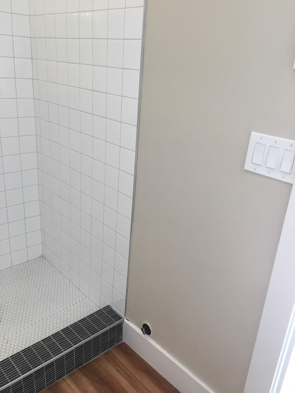 the door to the shower is open and the floor is tiled