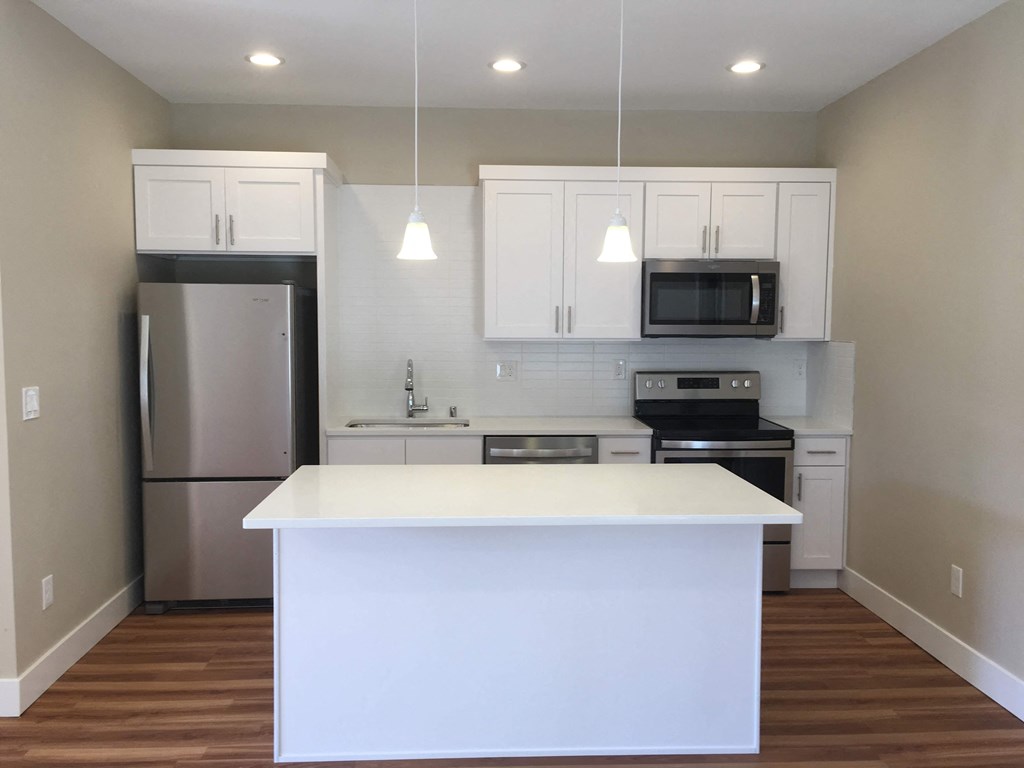 a kitchen with a white island and stainless steel appliances