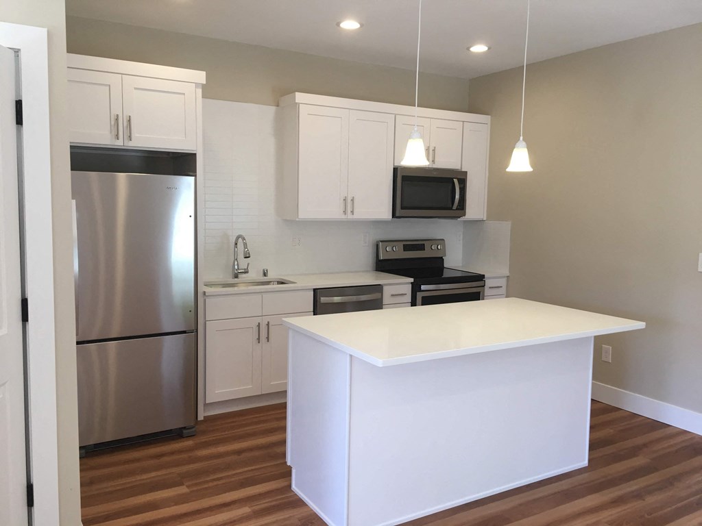 a kitchen with white cabinets and stainless steel appliances