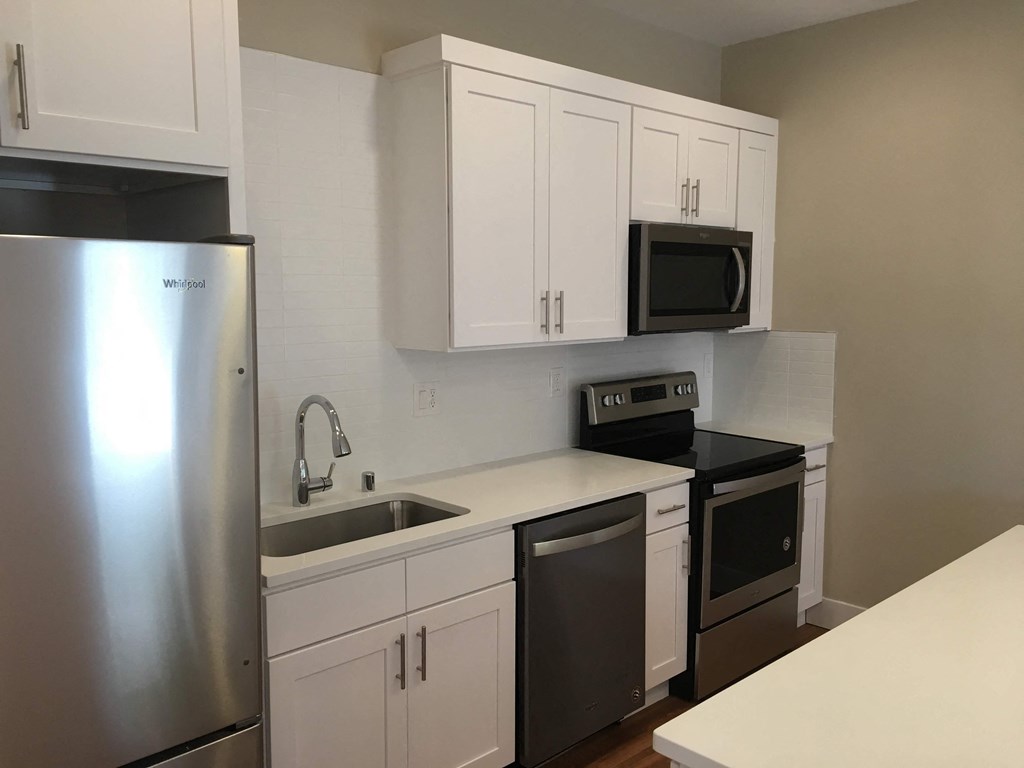 a kitchen with white cabinets and stainless steel appliances