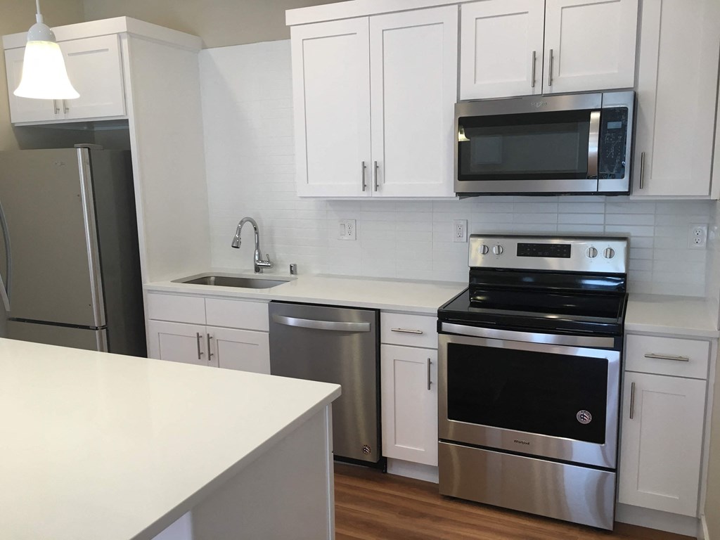 a kitchen with white cabinets and stainless steel appliances