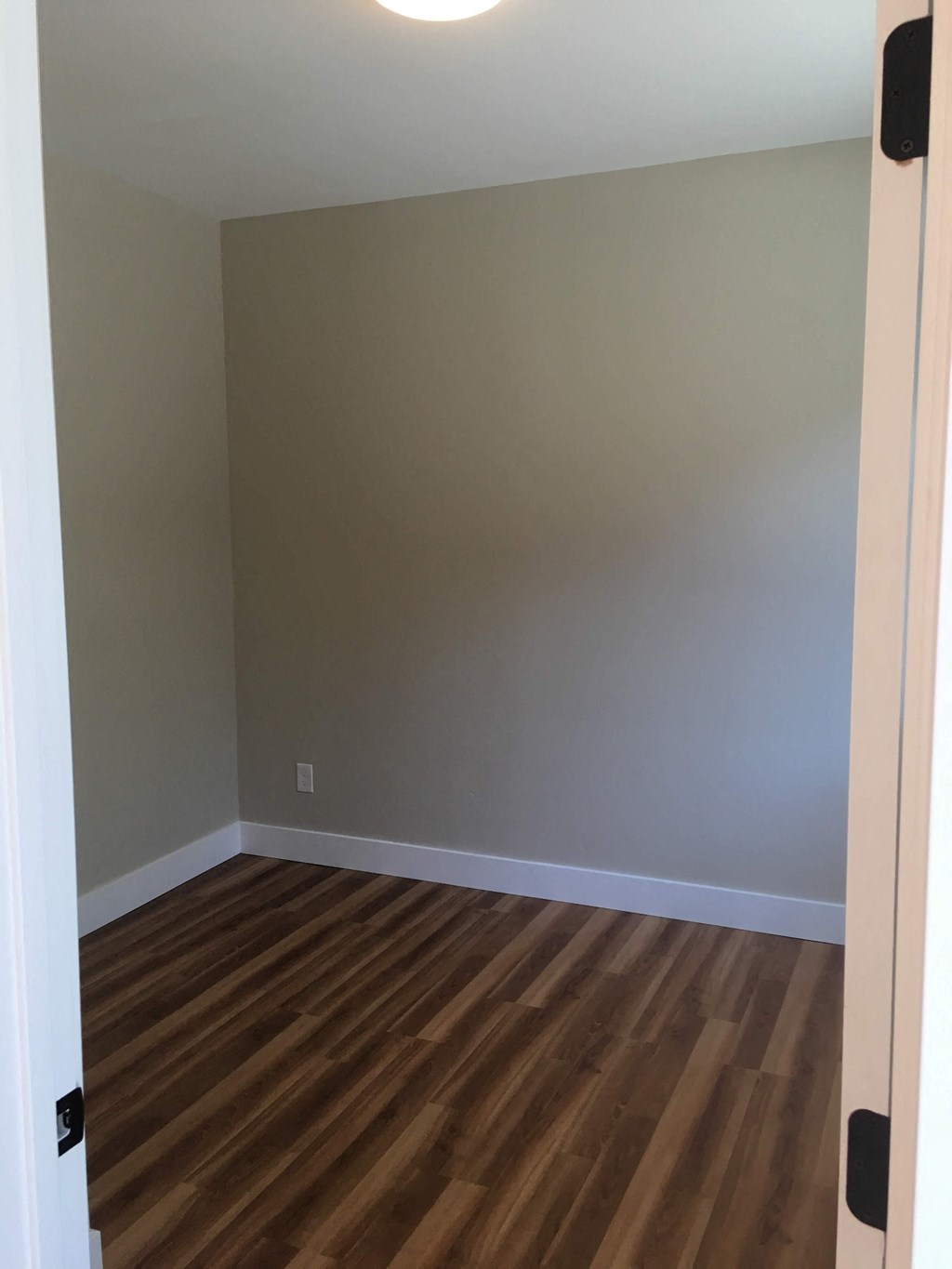 an empty room with wooden floors and a white door