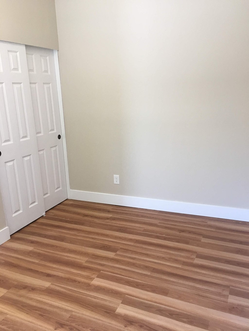 an empty room with wooden floors and a white door