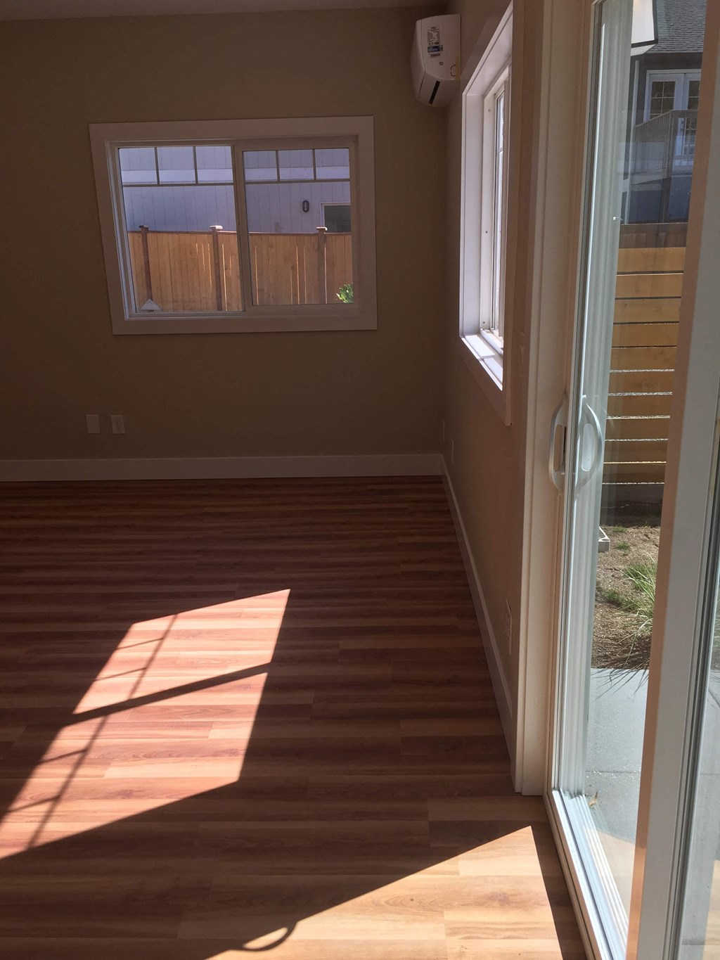 a room with a wood floor and a window