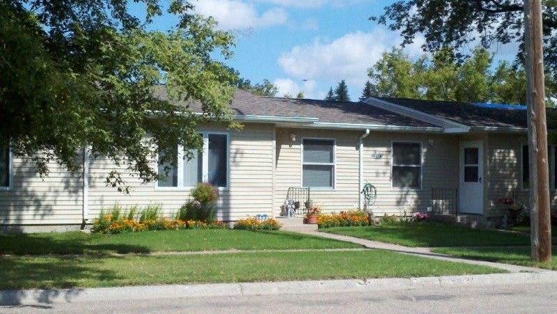 a white house with a sidewalk in front of it