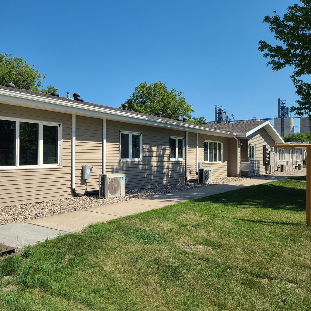 a tan house with a sidewalk in front of it