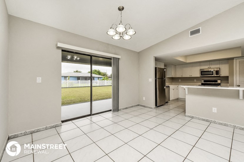 a large kitchen with a sliding glass door to the patio