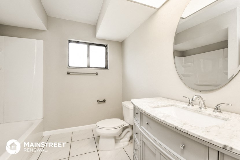 a bathroom with a toilet and a sink and a mirror